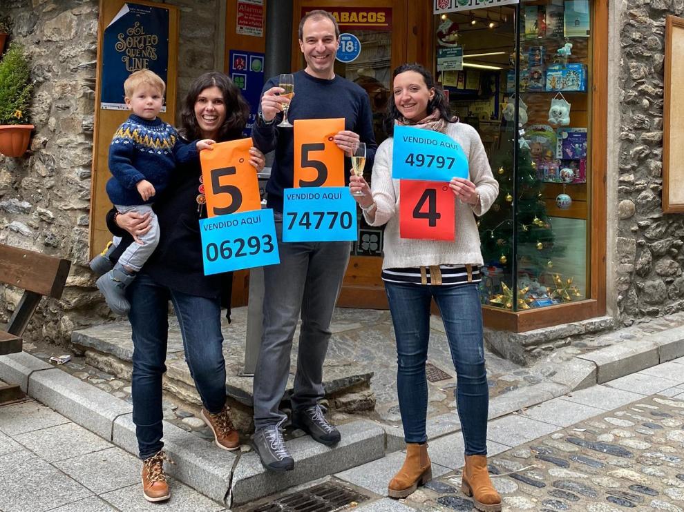 El estanco de Benasque ha repartido tres premios. En la foto, Christian Bielsa, hijo de la dueña, con su mujer, su hijo y una clienta.
