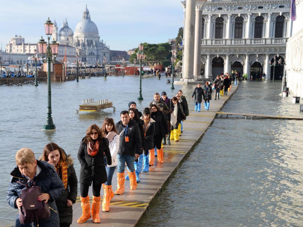 Venice (Italy), 23/12/2019.- A group of tourists walks in single file along a walkway, on the San Marco pier flooded by high tide, Venice, Italy, 23 December 2019. The high tide reached 144 cm. (Italia, Niza, Venecia) EFE/EPA/Andrea Merola High waters in Venice
