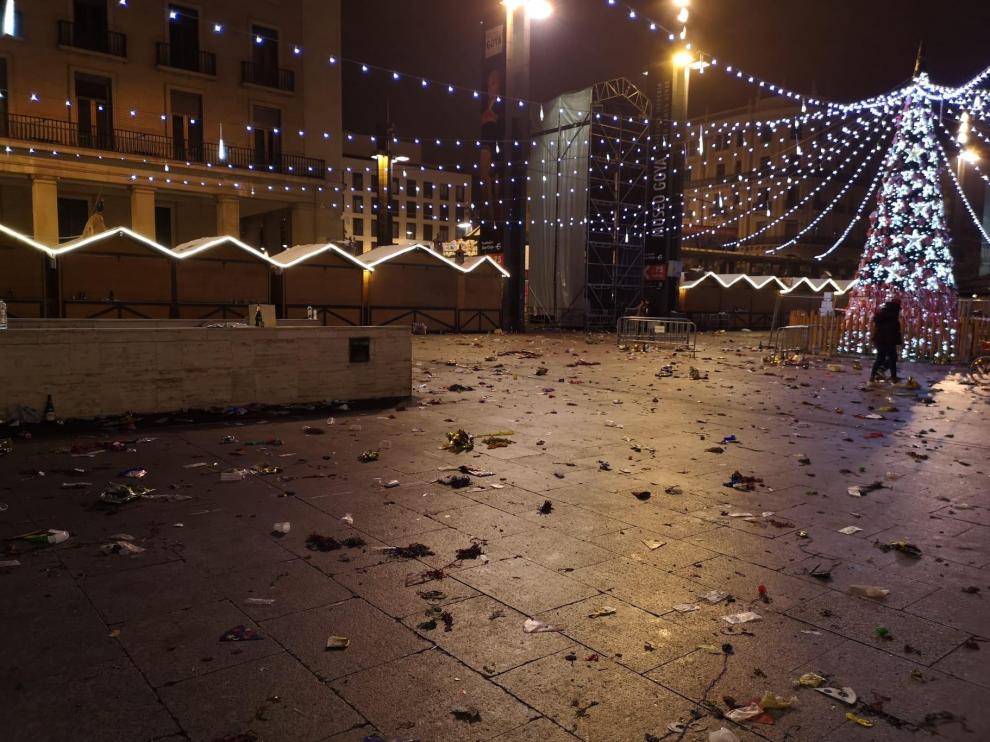 Las brigadas de limpieza han comenzado a las cinco de la mañana del día de Año Nuevo la limpienza de la plaza del Pilar, tras el cotillón de Nochevieja.