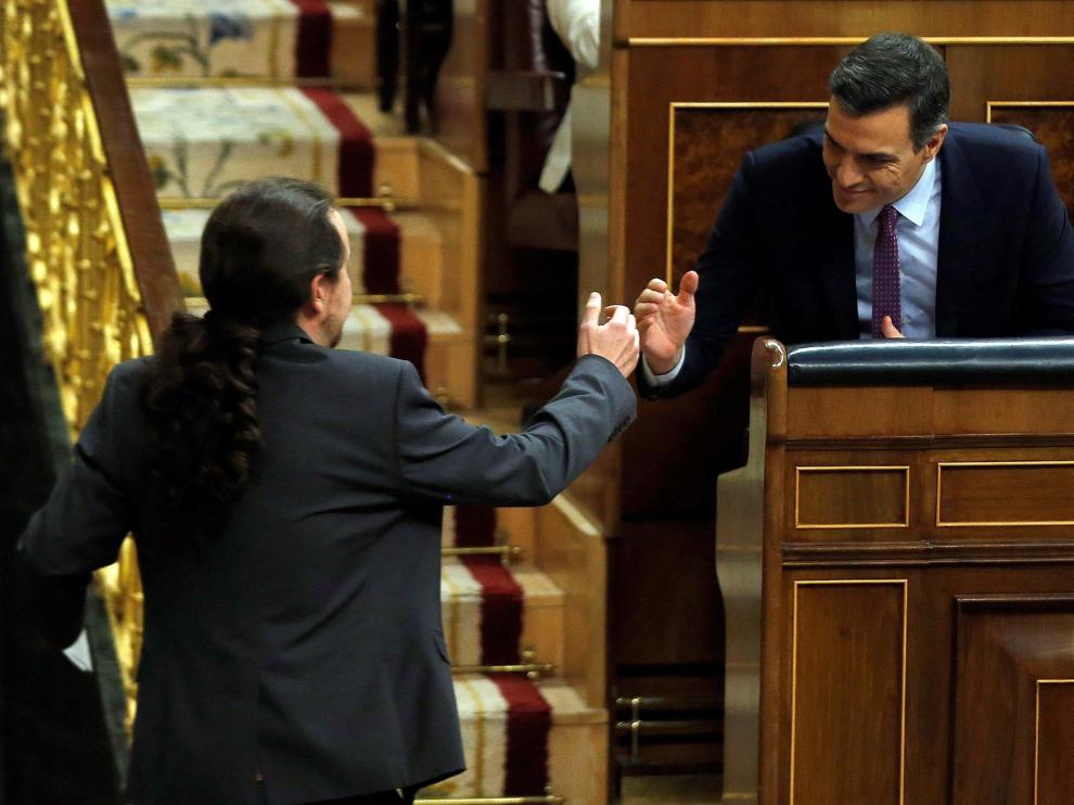 Pedro Sánchez y Pablo Iglesias se dan la mano.