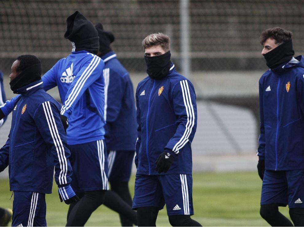 Igbekeme, Guti y Francés, acompañados por otros 'anónimos' compañeros protegidos del intenso frío en el entrenamiento matinal del Real Zaragoza en la Ciudad Deportiva.