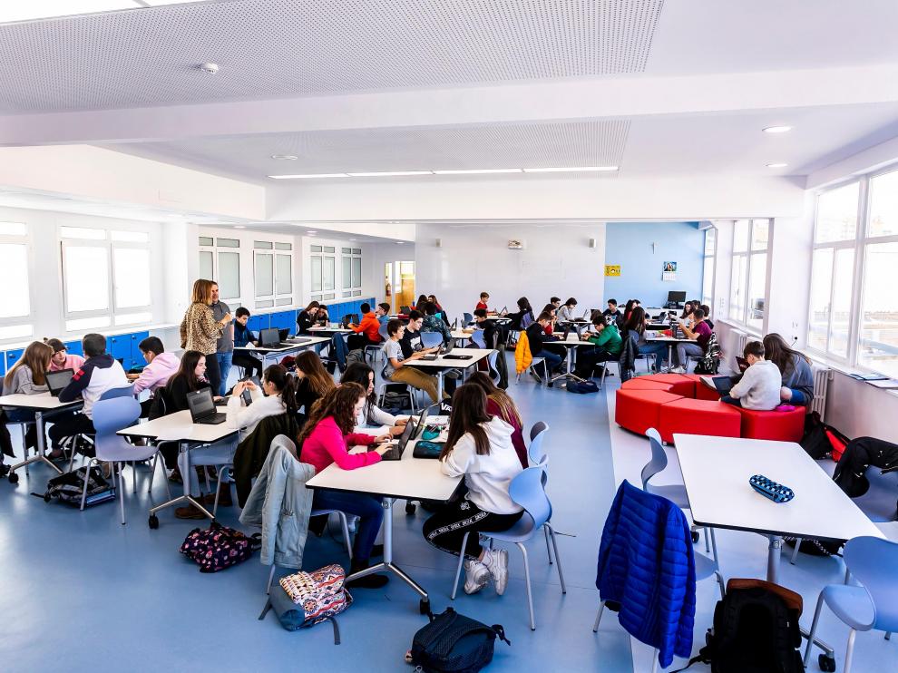 Varios docentes imparten clase a la vez a dos grupos de alumnos en el mismo espacio.