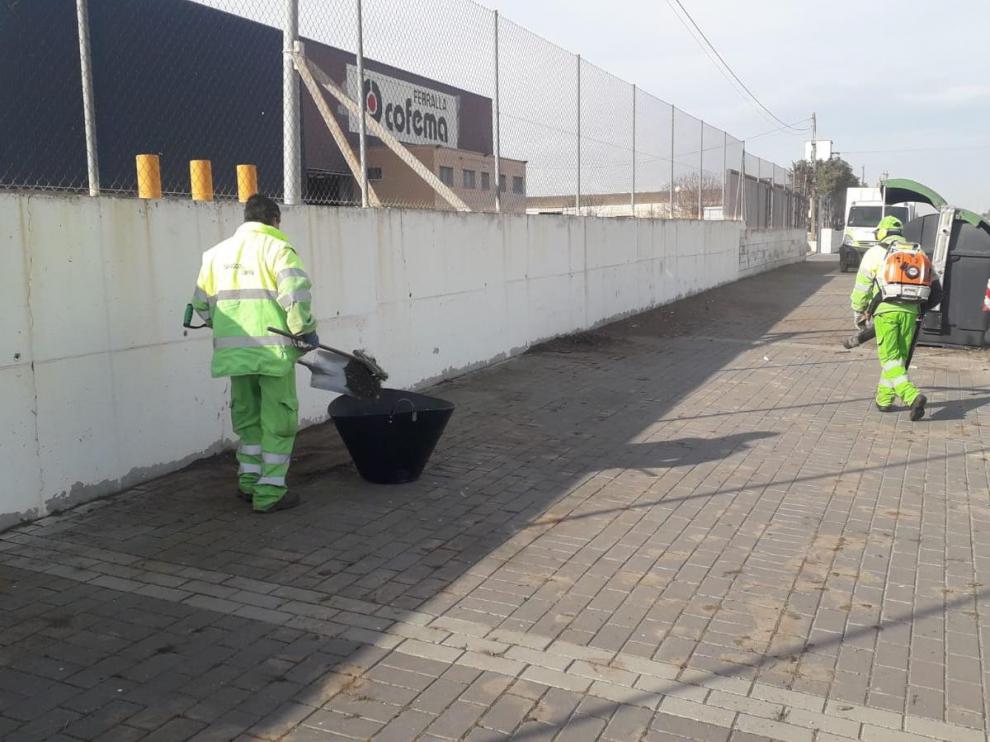 La brigada de limpieza de FCC limpia las aceras de la calle de Baleares.