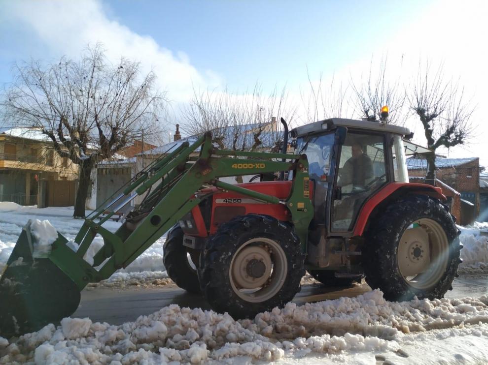 El alcalde de la localidad, Fernando Sánchez, despejando de nieve las carreteras del pueblo con su tractor.