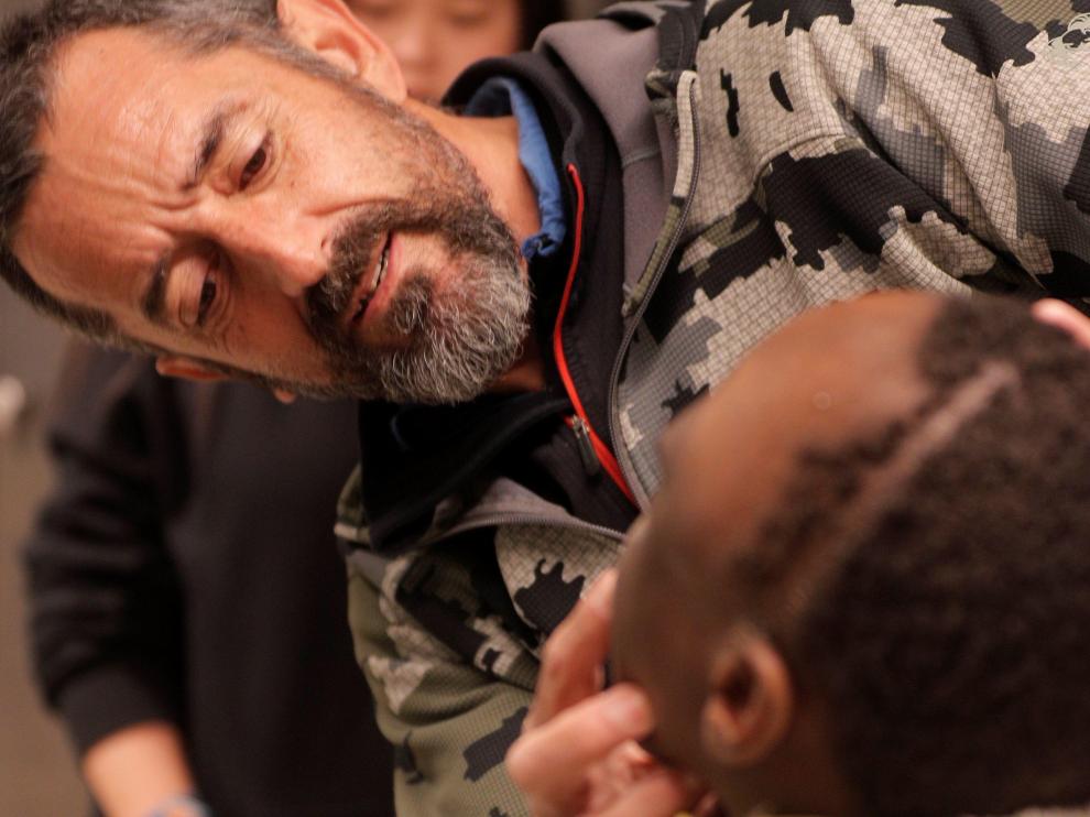 El cirujano Pedro Cavadas observa la cara de Emmanuelle, el niño congoleño de 10 años al que ha extirpado un tumor cráneo facial no maligno.