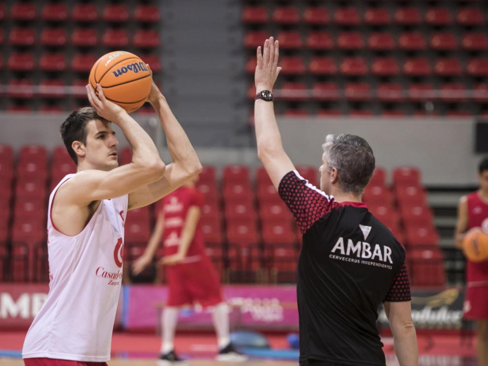 Nico Brussino, alero del Casademont Zaragoza, realiza un lanzamiento ante el técnico ayudante Manuel Peña.