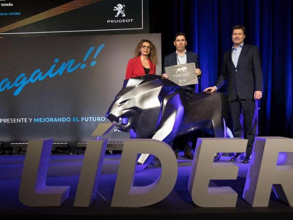 Francisco de Ayerbe (en el centro), gerente de PSA Retail Zaragoza, recibiendo el premio de Helene Bouteleau, directora general de Peugeot España, y Jaime Piedrola, director de ventas de Peugeot España.