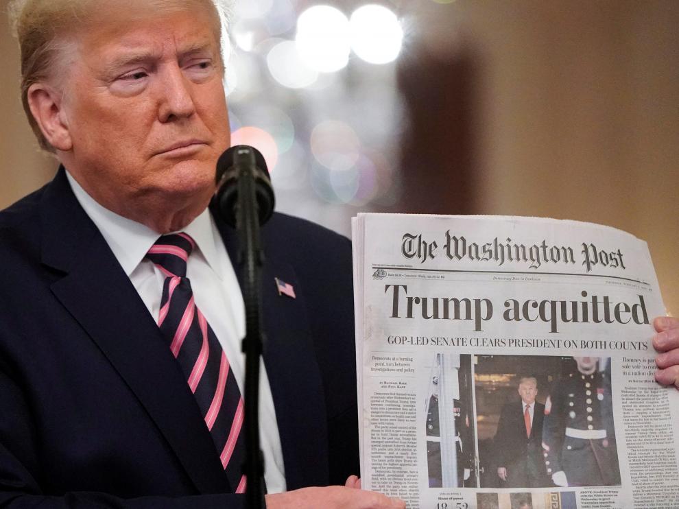 Trump sostiene un ejemplar del 'Washington Post' en el que se anuncia su absolución, este jueves en la Casa Blanca.