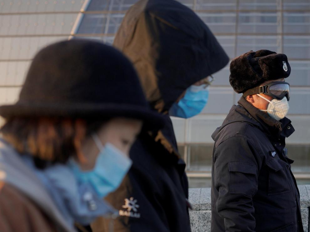 Un grupo de personas con máscaras, en Beijing.