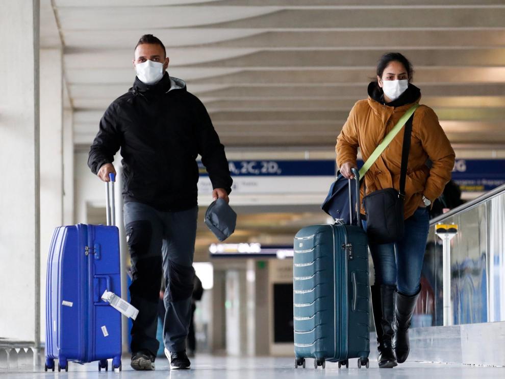 Dos personas con mascarillas en el aeropuerto de Charles de Gaulle en París.