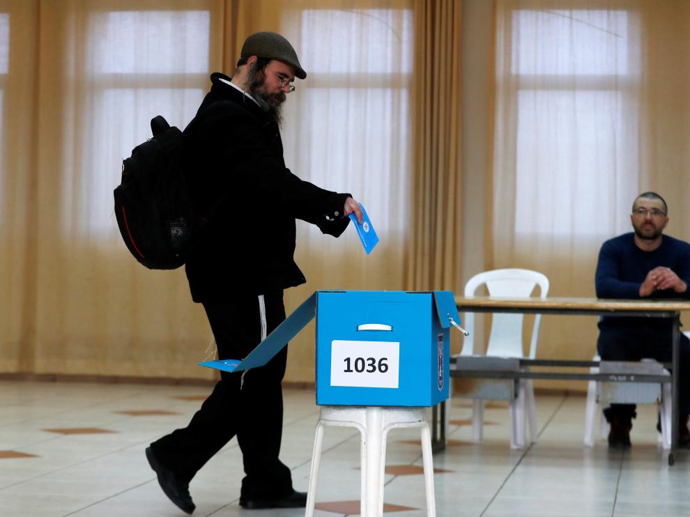 Un hombre introduce su voto en una urna en un colegio electoral del asentamiento judío de Nokdim