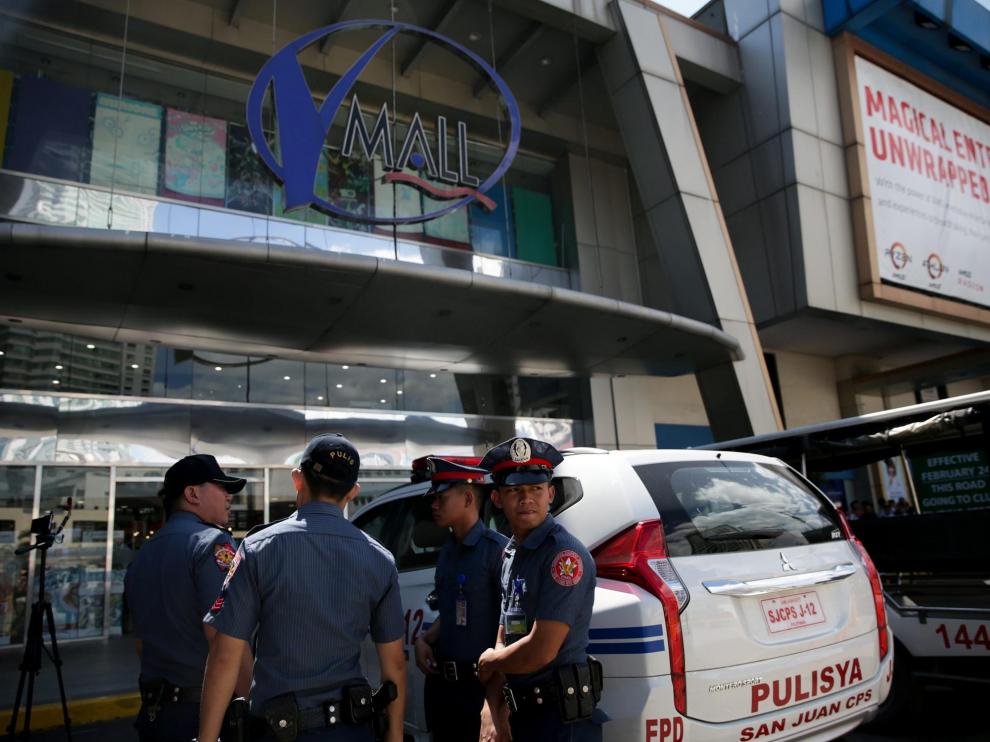 Varios policías, delante de una de las entradas al centro comercial.