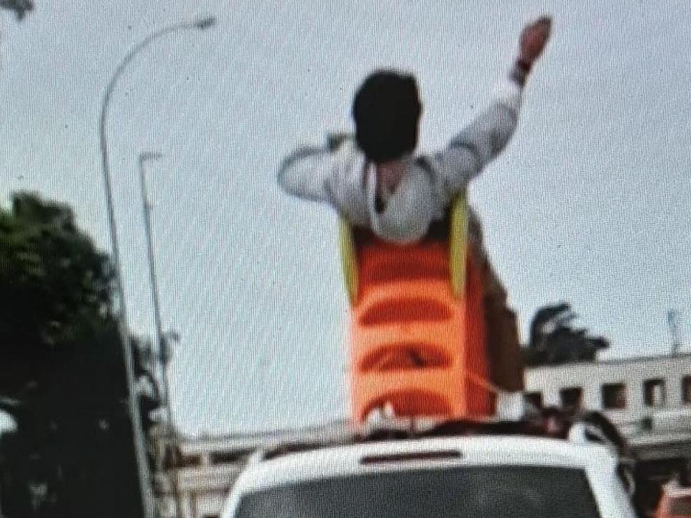 Circula sentado en un tobogán sobre el techo de un coche