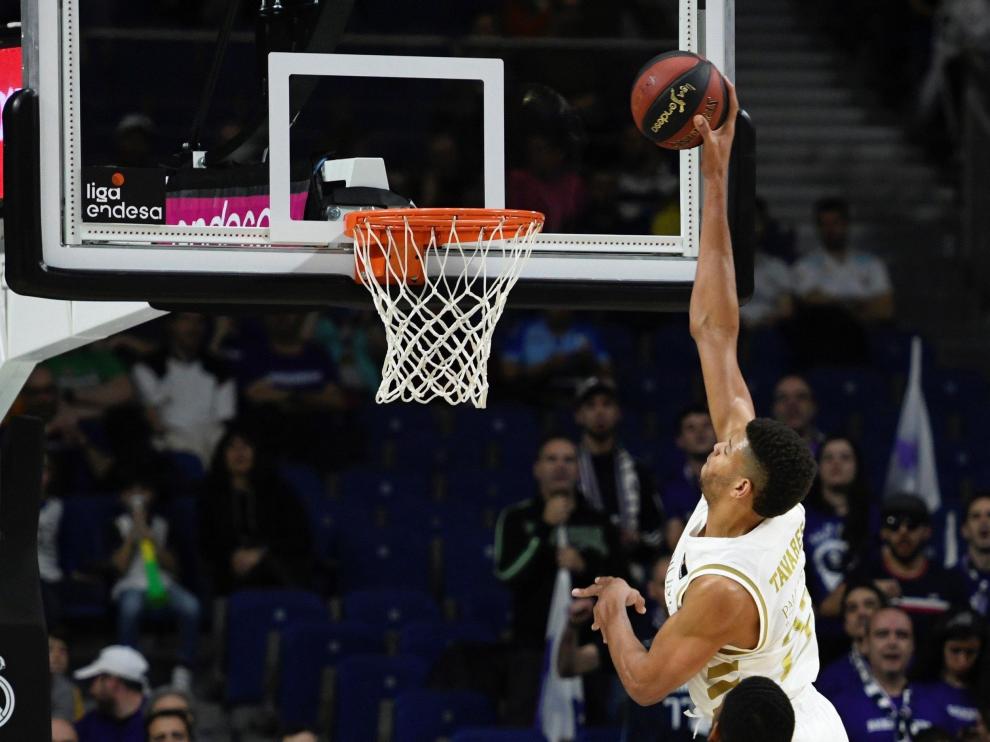 El pívot Walter Tavares (detrás) del Real Madrid, entra a canasta ante la mirada del pívot estadounidense Jason Thompson del Casademont Zaragoza