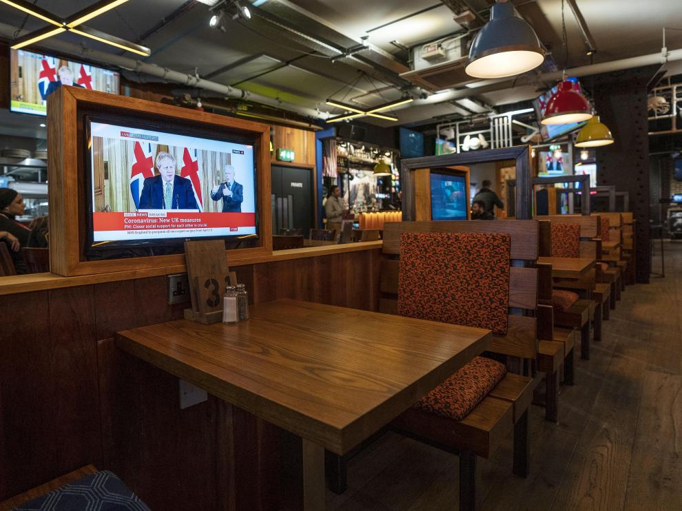 Una televisión muestra una imagen de Boris Johnson en un pub vacío en Londres.
