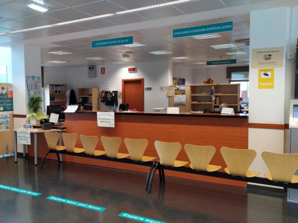 Una hilera de sillas evita que los usuarios se acerquen al mostrador en un centro de salud.