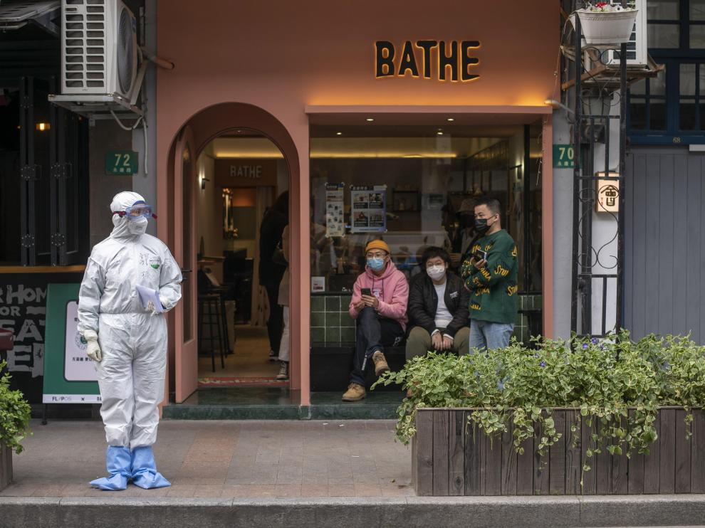 Una mujer completamente protegida contra contagios en una calle de Shanghai la semana pasada