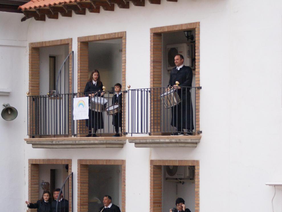 Tocando el tambor y el bombo desde balcones de la plaza del Ayuntamiento de Híjar.
