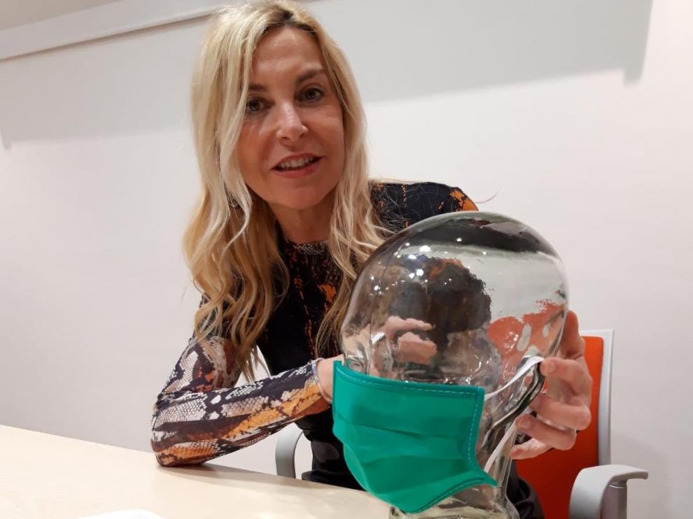 Victoria Bescós, directora comercial de la empresa Hollywood, de Fraga, con uno de los tres modelos que fabrican de mascarillas.