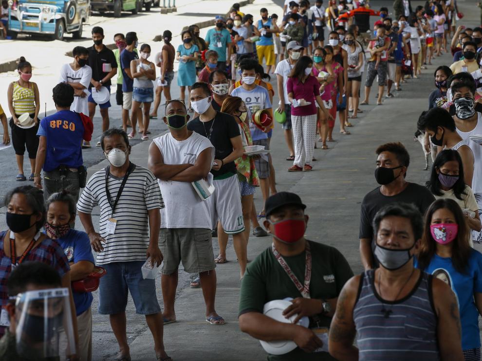 Decenas de filipinos hacen fila en Manila para conseguir alimentos gratis.