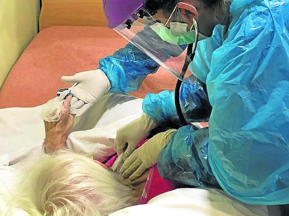 La doctora y el enfermero atienden a una anciana afectada