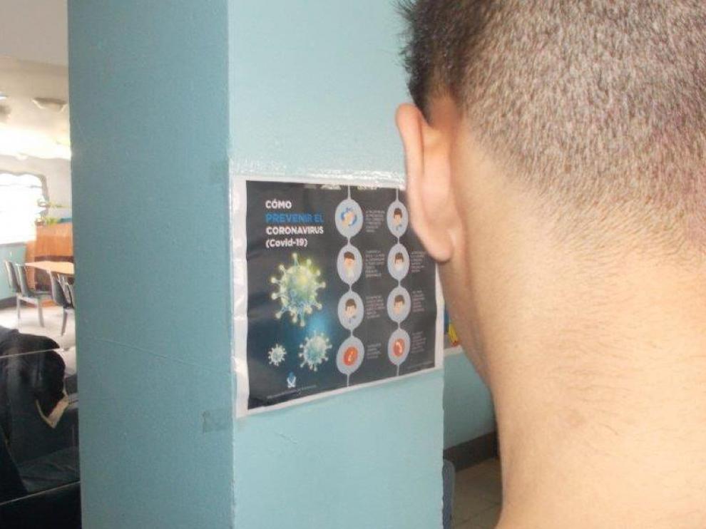 Un interno del centro de menores de Juslibol observa un cartel sobre el coronavirus.