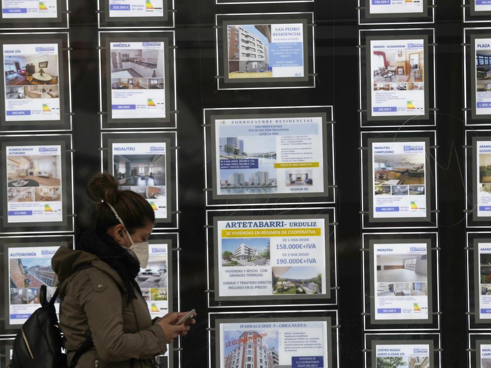 Una mujer pasa por delante de un portal inmobiliario de venta y alquiler en Bilbao este miércoles.