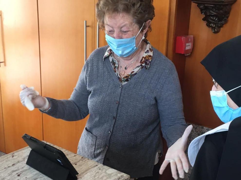 Una mujer mira una de las tablets donadas a residencias de Aragón.