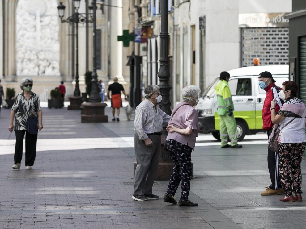Varias personas guardan la distancia social el domingo en Zaragoza.