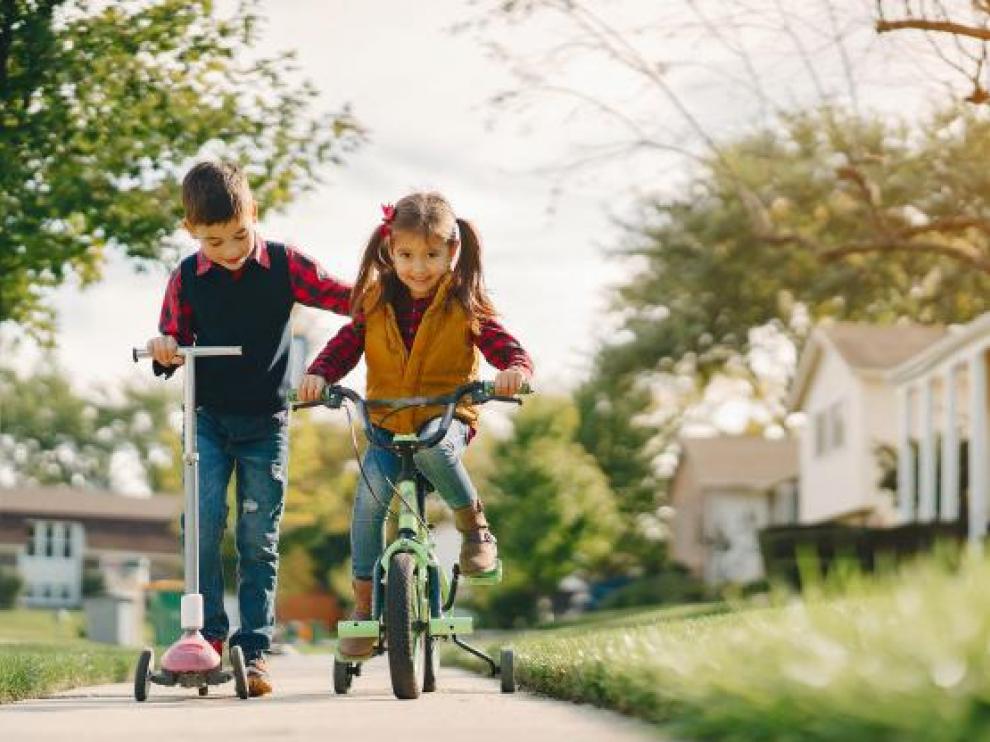 Las bicicletas y los patinetes son los compañeros de juegos de los pequeños en la calle.