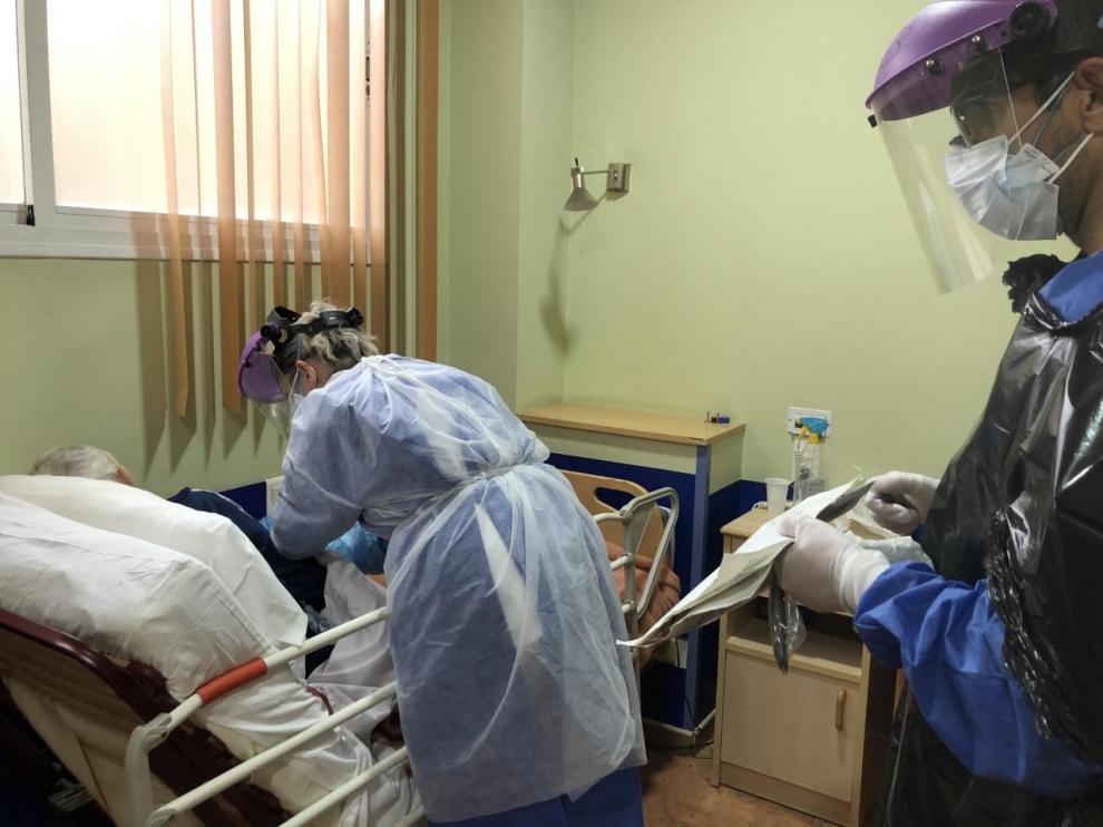 Una doctora y un enfermero atienden a un anciano con coronavirus