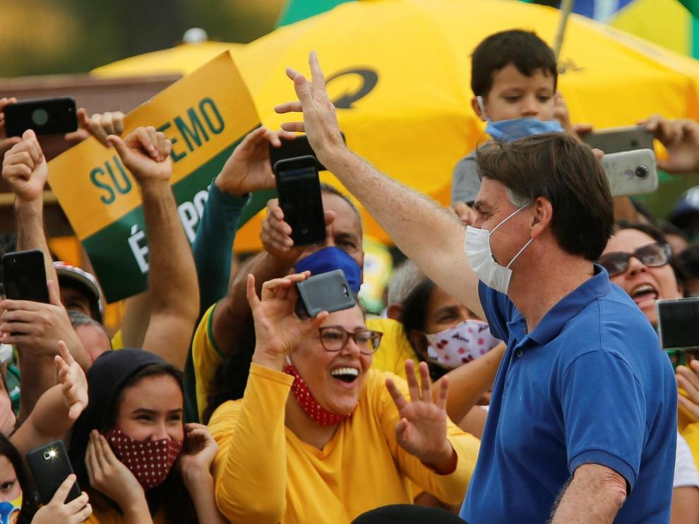 El presidente de Brasil, Jair Bolsonaro, saluda a algunos seguidores, este domingo en Brasilia.