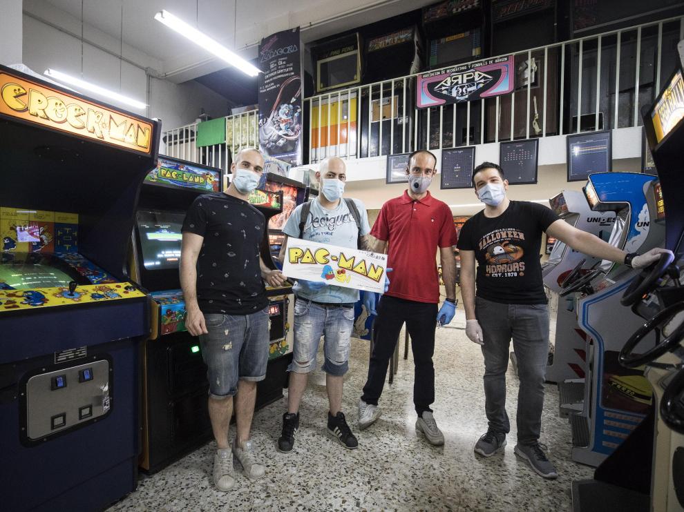 Eduardo Anay, Pedro Jesús del Monte, David Soler y Raúl Gascón, de ARPA, en su sede, rodeados de juegos 'arcade'.