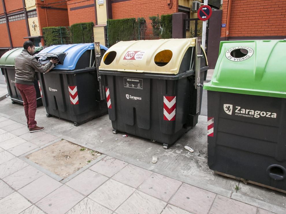 Una persona reciclando en un contenedor de papel en Zaragoza en una imagen de archivo.