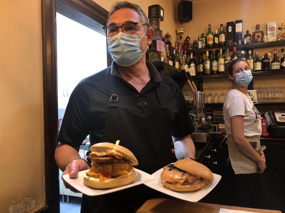 Edu Fernández con dos hamburguesas en las manos y su hija Ane en el San Petersburgo.