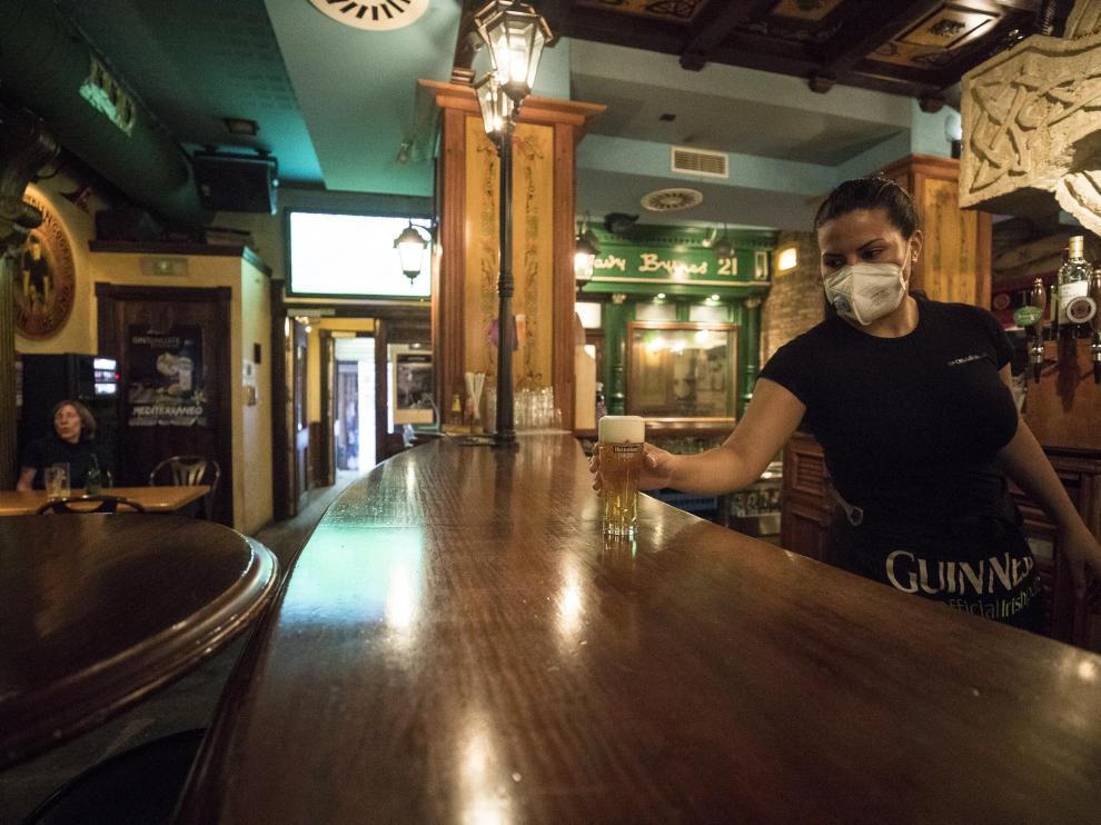 Una camarera atendiendo la barra del Bar Dublín, que abrió sus puertas en Zaragoza la semana pasada.
