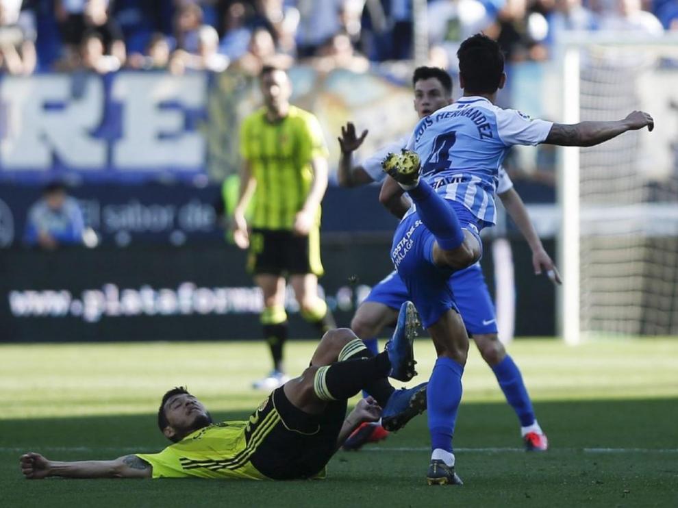 Un momento del último partido jugado por el Real Zaragoza, el de Málaga el 8 de marzo (0-1). En el suelo, Luis Suárez pelea con Luis Hernández.