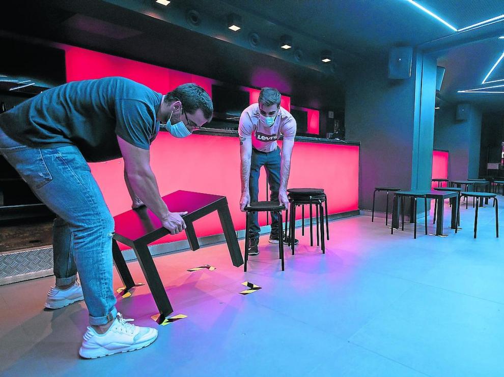Trabajadores del Hïde Club preparan las mesas en la pista de baile para abrir el viernes.