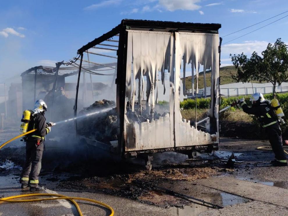 Los bomberos sofocal el incendio en un camión, que ha obligado a desviar el tráfico de la N-211 en Fraga
