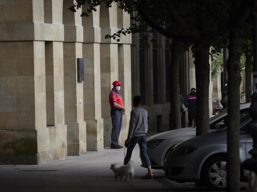Un agente de la Policía Foral con mascarilla en los soportales de una céntrica calle de Pamplona.
