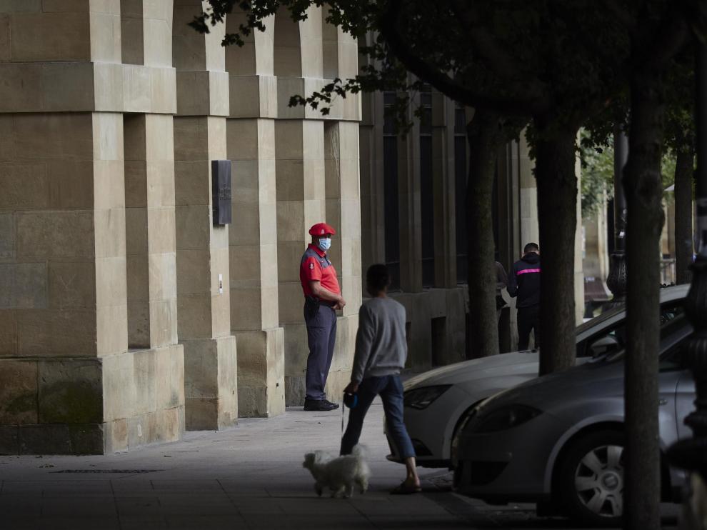 Un agente de la Policía Foral con mascarilla en los soportales de una céntrica calle de Pamplona.