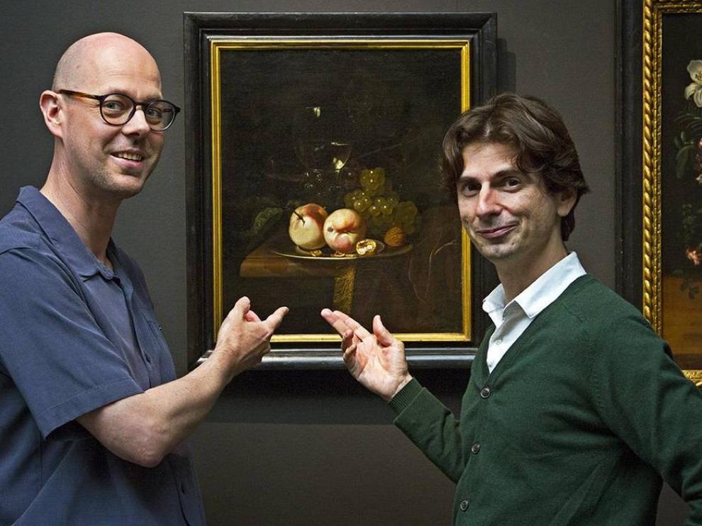 El biólogo Ive De Smet (izquierda) y el historiador David Vergauwen (derecha) frente a un bodegón con frutas.
