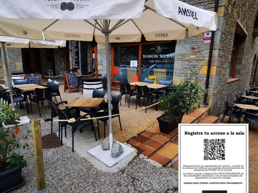 Terraza de la cafetería La Cumbre y detalle del cartel a las puertas.