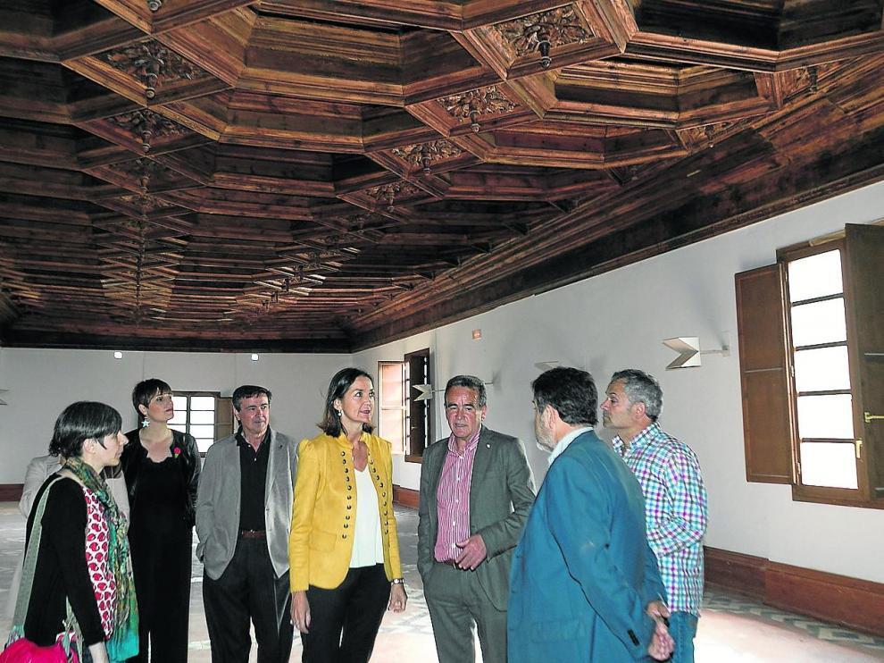 La ministra Reyes Maroto –en el centro–, junto al presidente de la DPZ y representantes políticos, en la biblioteca del siglo XVI durante la visita en mayo de 2019.