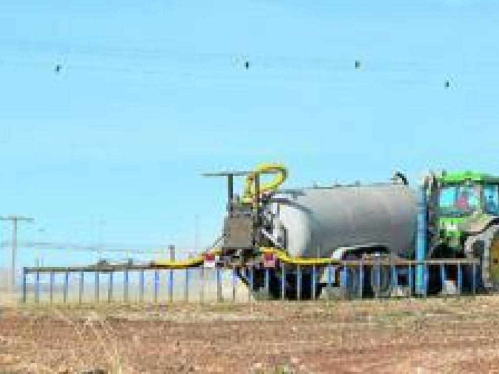 Una maquina aplica estiércoles liquidos para fertilizar el cultivo.