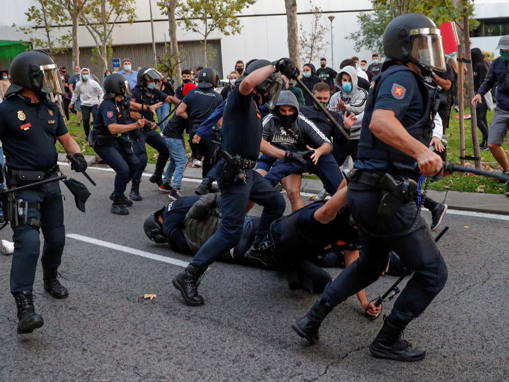 Miembros de la policía cargan contra un grupo de manifestantes que protestaban en favor de la Sanidad Pública y contra los confinamientos selectivos