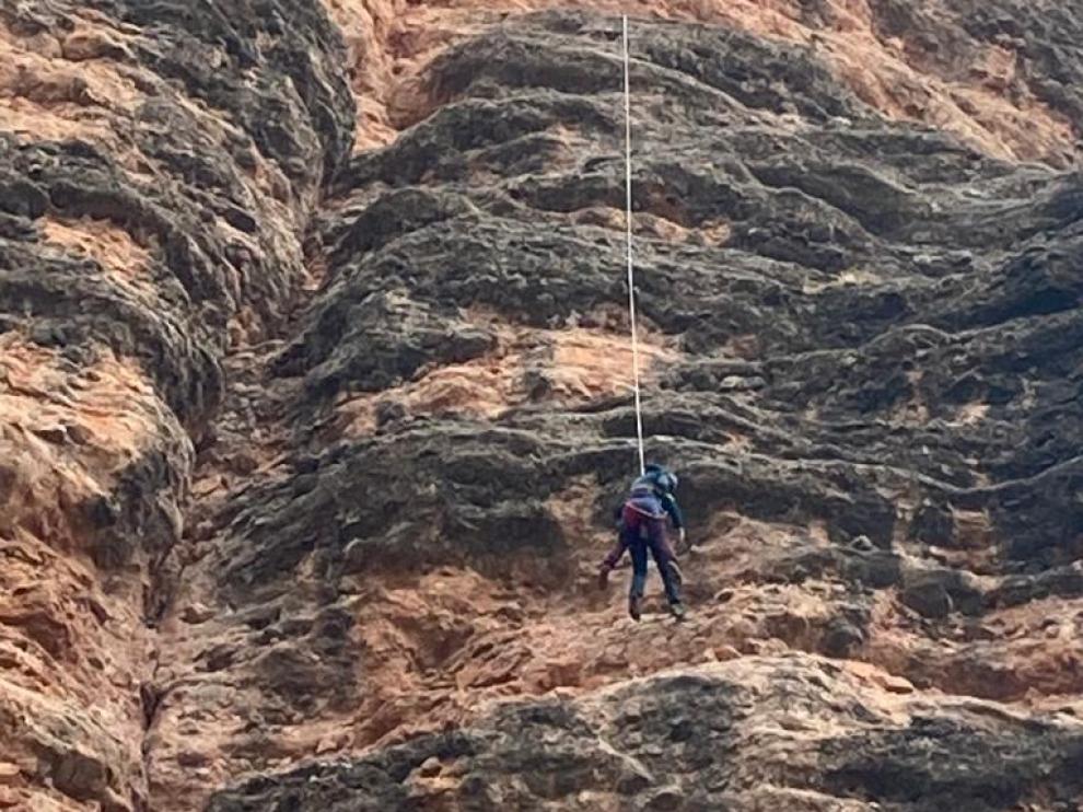 Un guardia civil desciende con la escaladora a la espalda.