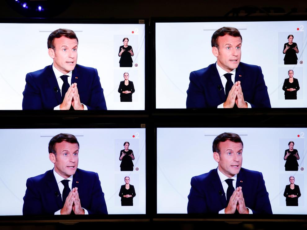 Emmanuel Macron, este miércoles en varias pantallas de televisión.