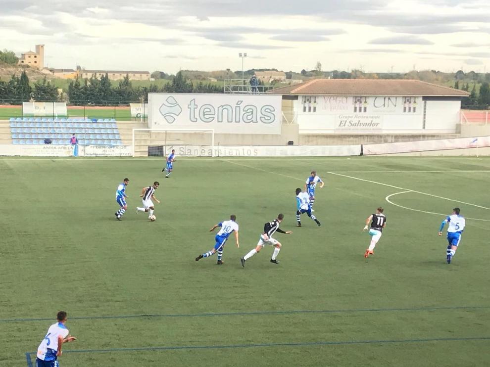 Un jugador del Haro Deportivo avanza con el balón mientras la defensa local trata de frenar su ataque.