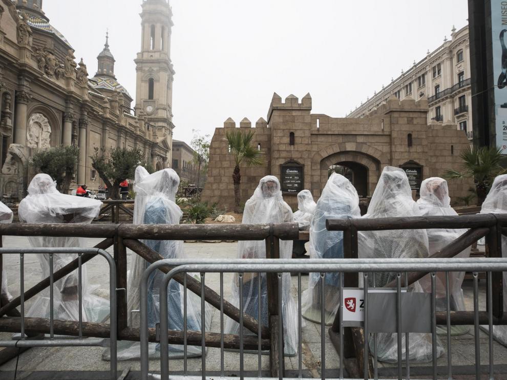 Las figuras del Belén del Pilar, protegidas por plásticos, durante el desmontaje.